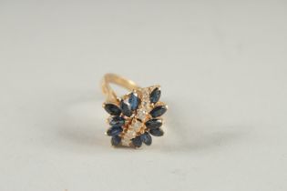 A 14CT DIAMOND AND SAPPHIRE CLUSTER RING.