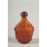 A CARVED AMBER SNUFF BOTTLE AND STOPPER. 3ins long.