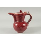 A Chinese red glazed pottery ewer. 12ins high.