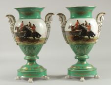 A PAIR OF SEVRES DESIGN TWO HANDLED URNS decorated with hunting scenes. 16ins high.