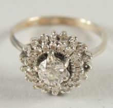 A 14CT WHITE GOLD DIAMOND CLUSTER RING.