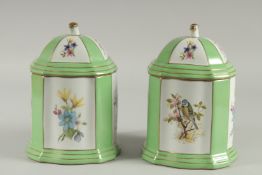 A PAIR OF SEVRES DESIGN GREEN LIDDED CANNISTERS with panels birds and flowers. 8 ins high.