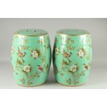 A PAIR OF GREEN PORCELAIN BARREL SEATS painted with birds. 18ins high.