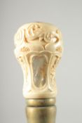 A WALKING STICK with carved bone and mother of pearl handle.