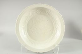A Chinese white glazed moulded pottery circular dish. 13ins diameter.