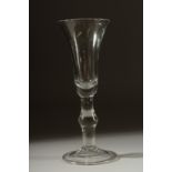 A GEORGIAN GLASS with long tapering plain bowl, knop to the stem. 7ins high.