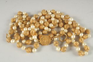 A GOOD LONG VINTAGE CHANEL GILT AND PEARL NECKLACE with old Chanel badge. 180cm long