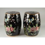 A PAIR OF FAMILLE NOIRE PORCELAIN BARREL SEATS painted with birds. 18ins high.