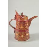 A Chinese pottery ewer, red glazed with gilded decoration. 9ins high.