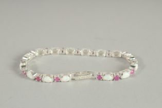 A SILVER RUBY AND OPAL LINE BRACELET.