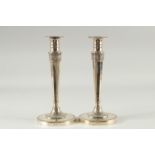 A PAIR OF CONTINENTAL SILVER CANDLESTICKS on circular bases. 10ins high.