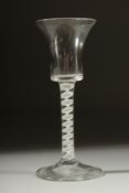 A GEORGIAN WINE GLASS with inverted bell shaped bowl and white twist stem. 6ins high.