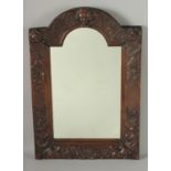 A GOOD 18TH CENTURY CARVED OAK ARCHED MIRROR carved with angels heads, shells and flowers. 23ins x