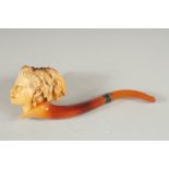 A MEERSCHAUM PIPE CARVED AS THE HEAD OF A LADY. Head, 5cm long, 6cm deeep with amber mouth piece.