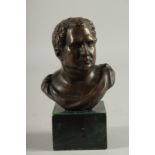 A BRONZE BUST HEAD OF A ROMAN. 4ins high on a marble base.