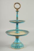 A SEVRES DESIGN TWO TIER CAKE STAND with gilt decoration. 18ins high.