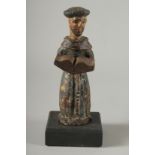 AN EARLY SPANISH CARVED WOOD TONSURED MONK on a square base. 8ins high.