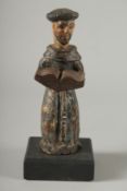 AN EARLY SPANISH CARVED WOOD TONSURED MONK on a square base. 8ins high.