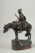 A SUPERB 19TH CENTURY RUSSIAN BRONZE "A COSSACK" holding gun, on a base. 11ins high.