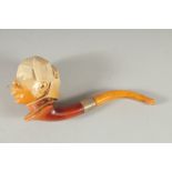 A MEERSCHAUM PIPE CARVED AS AN EGYPTIAN HEAD. 9cm long, 8cm deep with curving amber mouth piece in a