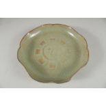 A CHINESE CELADON CRACKLE GLAZE PETAL FORM BOWL, the base with incised characters. 21cm wide.