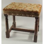 A GOOD 18TH CENTURY OAK STOOL with needlework top. 18ins high.