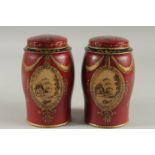 A SMALL PAIR OF RED TOLEWARE TINS AND COVERS. 7ins high.