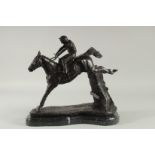 A BRONZE HORSE AND JOCKEY 'OVER THE STICKS' on a shaped marble base. 12ins high.