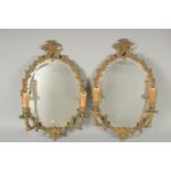A PAIR OF METAL OVAL MIRRORS with 2 scroiting bands