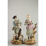 A PAIR OF SEVRES DESIGN PORCELAIN FIGURES of a man and a woman, sheep at her feet. 17ins high.