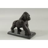 A BRONZE GORILLA on a marble base. 6ins long.