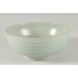 A CHINESE CELADON BOWL with ribbed exterior. 17ins diameter.