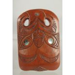 A MAORI CARVED WOOD MASK with mother of pearl eyes. 8.25ins x 6.5ins.