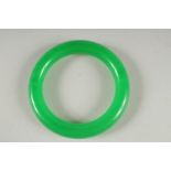 AN APPLE GREEN JADE BANGLE. 3.25ins diameter.