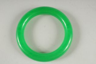 AN APPLE GREEN JADE BANGLE. 3.25ins diameter.