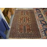 A modern Persian style carpet, rust ground with three central panels, 200cm x 120cm.