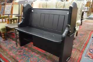 A small pew with later black painted decoration.