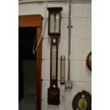 A Negretti & Zambra oak cased stick barometer together with another thermometer gauge.