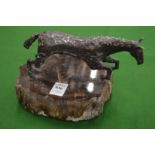 A white metal model of a rearing horse on hard stone base.