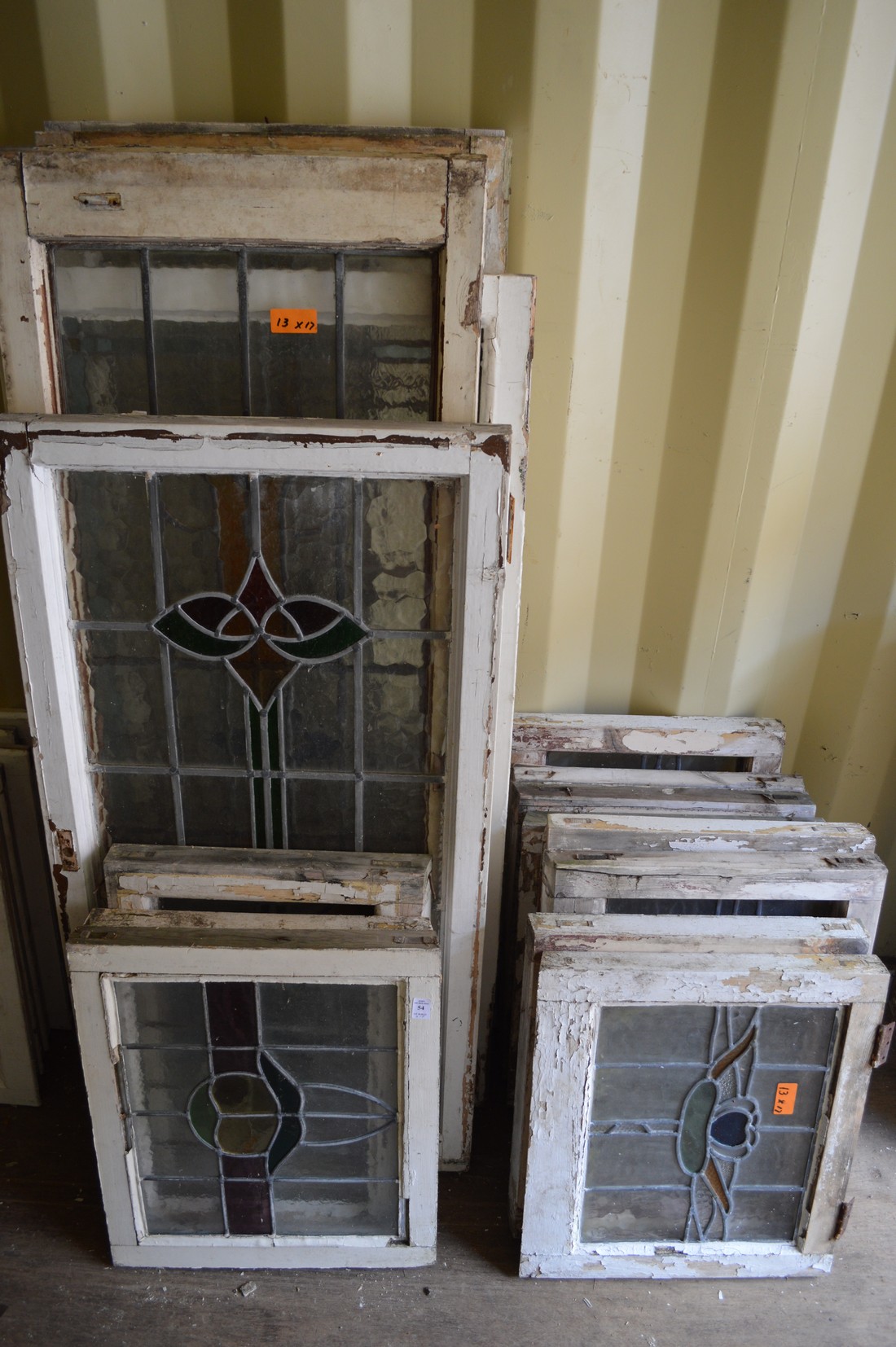 Thirteen various framed leaded lights with stained glass decoration.