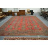 A large Turkish carpet, red ground with stylised decoration (faults), 540cm x 400cm.