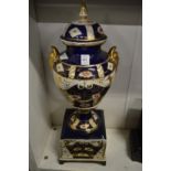 A large porcelain urn on stand decorated in Imari colours (faults).