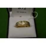 A 14ct gold band with chased decoration, size T.