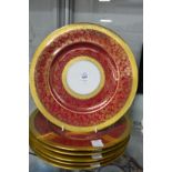 A set of six red ground and gilt decorated dinner plates.
