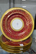 A set of six red ground and gilt decorated dinner plates.