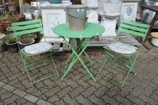 A painted bistro set comprising folding table and pair of folding chairs.