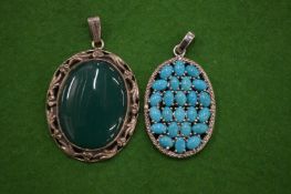 Two decorative silver and hardstone pendants.