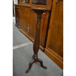 A mahogany torchere.