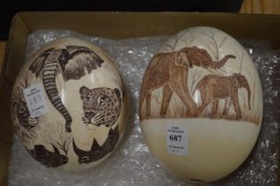 Two decoratively engraved emu eggs.