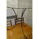 A wrought iron and glass top circular occasional table.